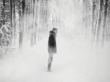 Full length of man standing in forest during winter