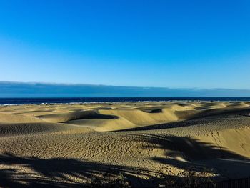 Scenic view of beach against clear blue sky