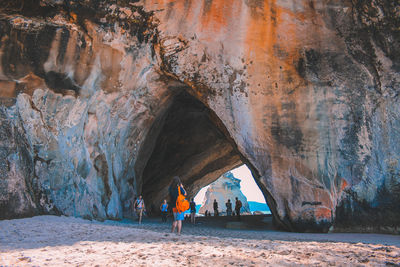 People on rock formation in cave