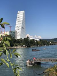 Scenic view of sea by buildings against clear sky