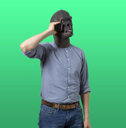 Midsection of man photographing against gray background