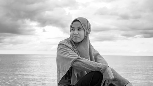 Woman in sea against sky