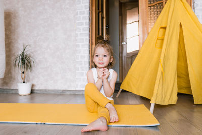 Portrait of smiling girl sitting on floor