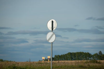 Road sign the end of all restrictions on the background of a cloudy sky