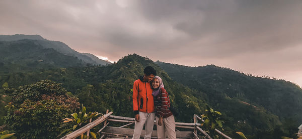 People standing on mountain against sky