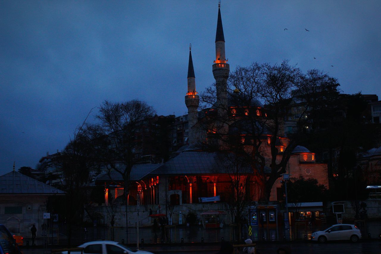 building exterior, architecture, built structure, building, sky, city, tree, illuminated, dusk, nature, mode of transportation, plant, motor vehicle, tower, car, transportation, religion, night, place of worship, residential district, outdoors, no people, spire