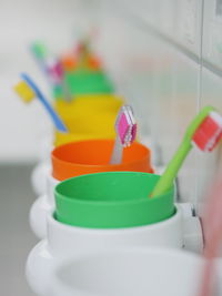 Close-up of colorful toothbrushes in containers at bathroom