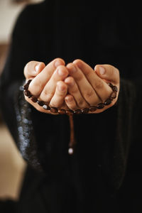 Prayer hands of a woman holding a rosary. ramadan kareem