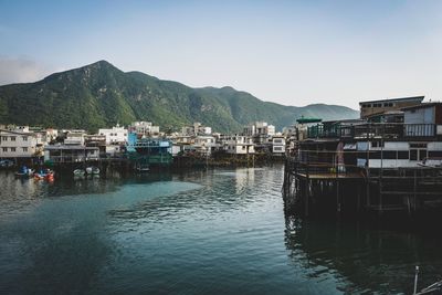 Stilt houses over lake against sky