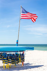 Lifeguard hut on beach against blue sky