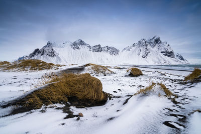 Scenic view of snow covered mountains against sky