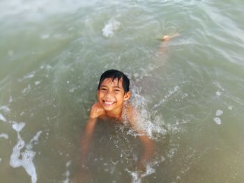 Portrait of smiling boy swimming in water