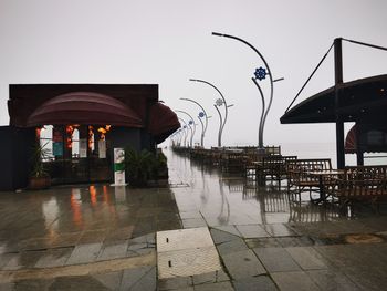 Wet table by street against sky during rainy season