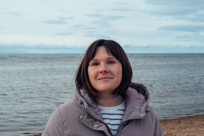 Portrait of a happy woman on the beach in cold weather. the concept of mental health