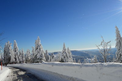 Scenic view of snow covered landscape against blue sky