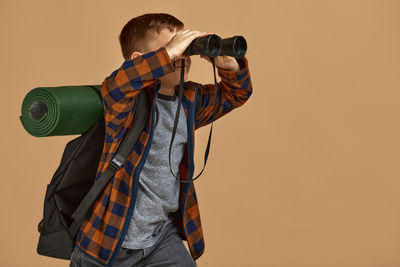 Rear view of man photographing against blue background
