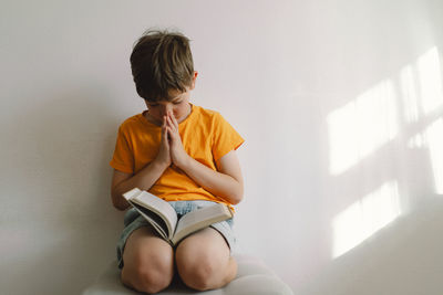 Christian boy holds bible in her hands. reading the holy bible.