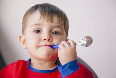 Close-up portrait of cute boy against white background