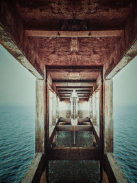 Interior of pier over sea against sky