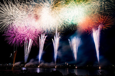 Low angle view of illuminated fireworks against sky at night