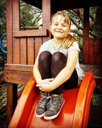 Portrait of smiling boy sitting outdoors