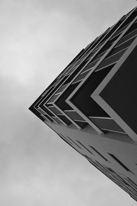 Low angle view of office building against cloudy sky