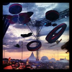 Panoramic shot of crowd hanging against sky during sunset