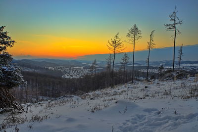 Scenic view of snow covered mountain against sky during sunset