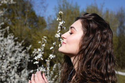 Close-up of young woman smelling flowers