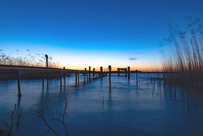 Scenic view of lake against clear sky during sunset