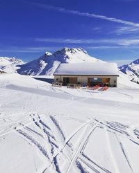 Built structure on snow covered mountain against sky in lech 