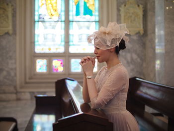 Side view of bride sitting in pew