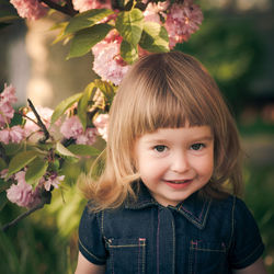 Portrait of smiling woman with pink flower