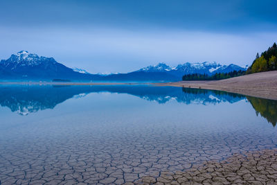 Scenic view of lake and mountains against blue sky