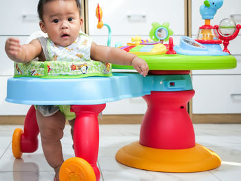 Cute boy playing with toy on table