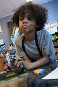 Portrait of boy holding camera at home