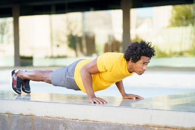 Side view of young man with arms outstretched