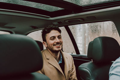 Close-up of happy businessman traveling in car