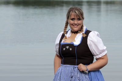 Portrait of smiling young woman standing in water