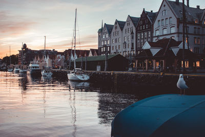 Boats moored at harbor against buildings in city