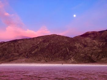 Scenic view of sea and mountains against sky during sunset