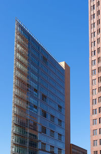 Low angle view of modern building against clear blue sky