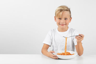 Portrait of smiling boy against white background