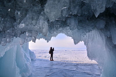 Rear view of people on frozen sea during winter