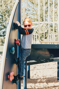 Full length of boy standing on play equipment