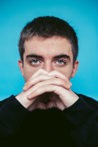 Portrait of young man against blue background