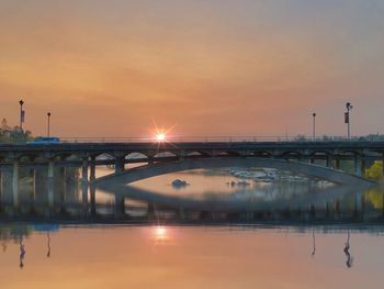 Bridge over lake against sky during sunset