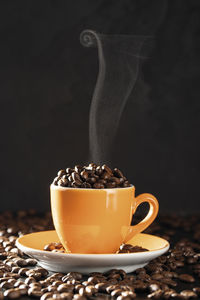 Close-up of coffee cup on table against black background