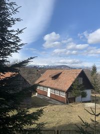 Houses by buildings in city against sky