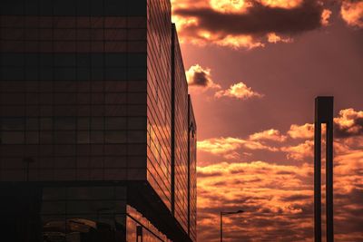 Low angle view of modern building against sky at sunset